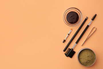 Flat lay composition with eyebrow henna and professional tools on orange background, space for text