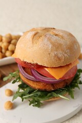 Tasty vegetarian burger with chickpea cutlet on white table, closeup