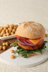 Tasty vegetarian burger with chickpea cutlet on white table