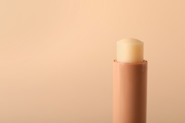 Lip balm on beige background, closeup. Space for text