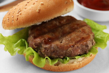 Delicious fried patty, lettuce and buns on white table, closeup. Making hamburger