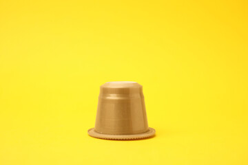 One plastic coffee capsule on yellow background