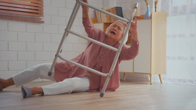 Asian caregiver help senior female from falling on the ground at home. 