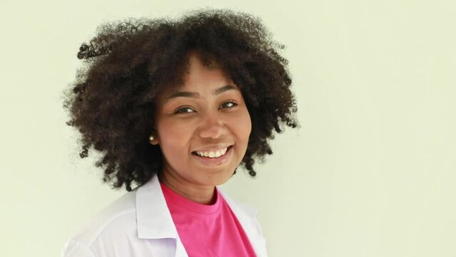 Portrait of a cute, healthy African American female nutritionist smiling and raising her hands in greeting, looking at the camera in a good mood.