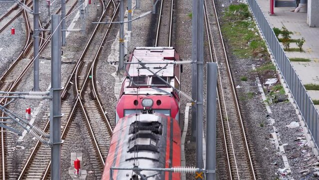 View from the top of a train coming from the top-middle to the bottom of the frame, passing by Bang Sue train station in Bangkok, Thailand.
