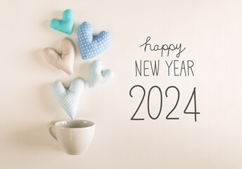 Fototapeta na wymiar New Year 2024 message with blue heart cushions coming out of a coffee cup