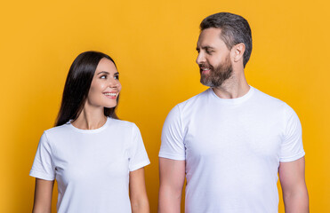 Couple of man and woman isolated on yellow. Family couple relationship. Millennial man and woman wearing white tshirt. Casual style of millennial couple. Boyfriend girlfriend. Two friends