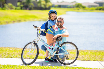 Obraz premium daddy and son kid outdoor. daddy and son spend time together. Supportive family dynamics. happy son and daddy cycling on bicycle. daddy teaching his son child to ride a bicycle