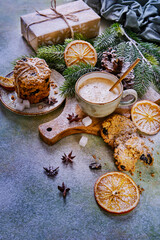Christmas tree branches, gift box, coffee and oatmeal cookies on the table under the snow. New Year's composition
