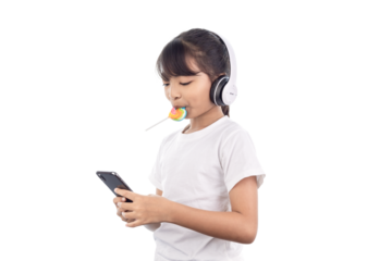 A happy Asian young girl playing music with her smartphone and wearing headphones and eating a lollipop isolated on white background with clipping path.