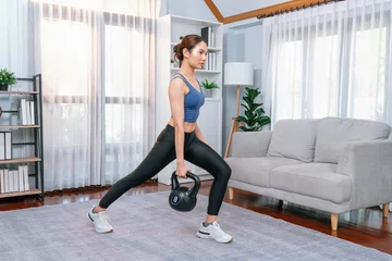 Crédence de cuisine en verre imprimé Fitness Vigorous energetic woman doing kettlebell weight lifting exercise at home. Young athletic asian woman strength and endurance training session as home workout routine.