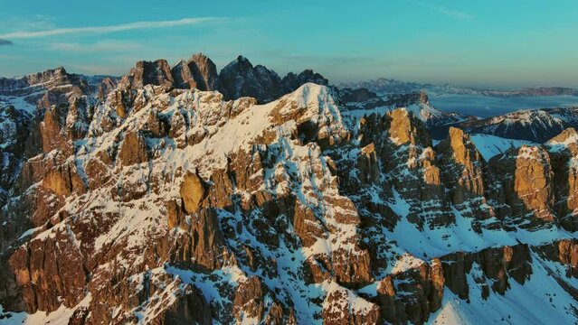 Aerial view of amazing rocky mountains in snow at sunrise, Dolomites, Italy, 4k