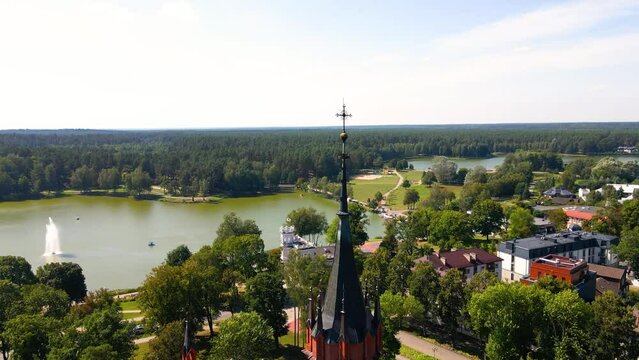 Aerial shot of the Catholic Church of Saint Mary's Scapular roof and the cross in Druskininkai, Lithuania on a sunny summer day