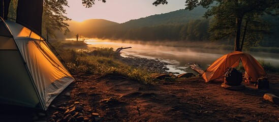 camping with a tent on the river bank with sunlight in the morning and clear river water and natural views