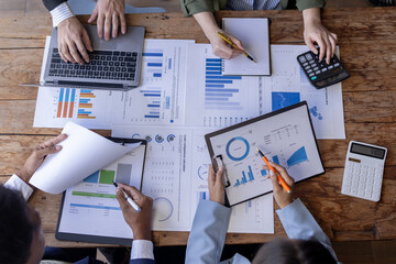 Group of confident business people point to graphs and charts to analyze market data, balance sheet, account, net profit to plan new sales strategies to increase production capacity.	 - obrazy, fototapety, plakaty