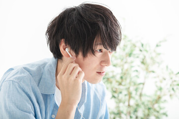 イヤホンで音楽を聴く男性　man listening to music with earphones