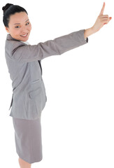 Digital png photo of smiling asian businesswoman pointing with finger on transparent background