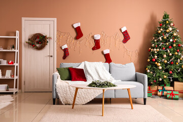 Interior of living room with sofa, Christmas socks and fir tree