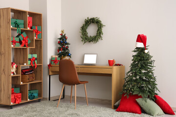 Interior of office with workplace, laptop and Christmas presents