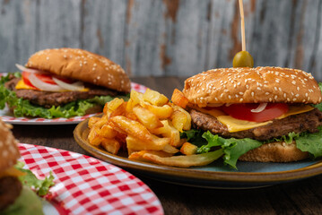 Homemade hamburger with fries on a wooden table.
