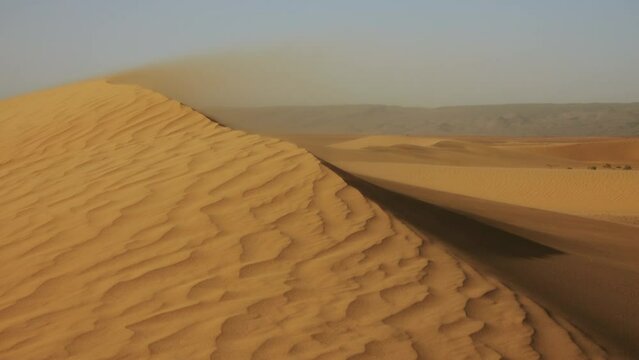Sand blowing over large sand dunes in wind, Sahara desert, 4k