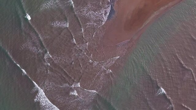 crystal clear water of philippine ocean, waves gently splashing on one of the sandbars in surigao philippines, aerial drone rotating overhead shot