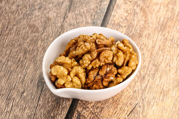 Cracked unshelled walnut in the bowl