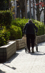 冬の街で歩く一人のシニア女性の姿