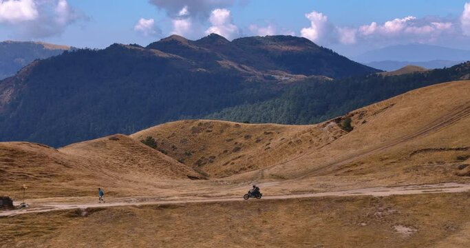 drone shot of a male riding motorbike in Nepal, PikeyPeak, hilly region, adventure 4K