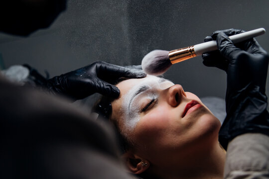 The makeup artist performs permanent makeup. Professional makeup and facial care. Eyebrow and lip tattooing. Cosmetologist. Beauty salon.