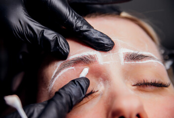 The makeup artist performs permanent makeup. Professional makeup and facial care. Eyebrow and lip...