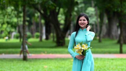 A young girl wearing a jade-green ao dai the traditional costume of Vietnam. Photo for tourism, culture, tradition, and the beauty of Asian people. Idea for train model in computer vision systems