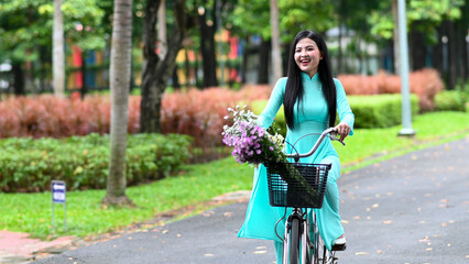 A young girl wearing a jade-green ao dai the traditional costume of Vietnam. Photo for tourism,...