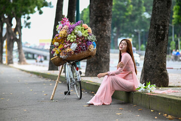 A young girl wearing a lotus pink color ao dai the traditional costume of Vietnam. Photo for...