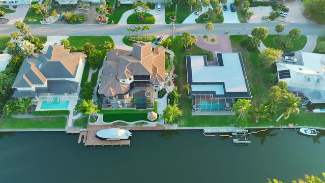 Expensive mansions between green palm trees on Gulf of Mexico shore in Sarasota city in Florida, USA. Aerial view of wealthy waterfront neighborhood. Premium housing development