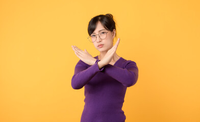 An attractive woman wearing a purple shirt and eyeglasses, making the X sign with her arms, a clear...