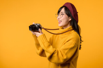 A professional photographer, this young Asian woman in her yellow sweater and red beret captures...