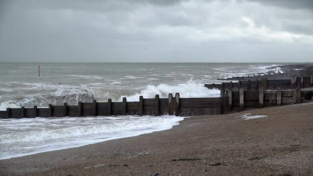In slow motion large and threatening waves break between groynes and crash on to the beach as storm Ciar&aacute;n makes landfall.