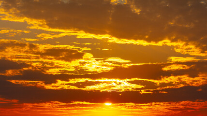 Naklejka na ściany i meble Golden sunset on the sky with clouds