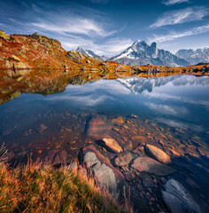 Beautiful autumn scenery. Colorful hills on Chesery lake, Chamonix location. Rocky outdoor scene of...