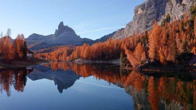 4k drone flight moving to the side footage (Ultra High Definition) of popular tourist destination - Federa lake among larch trees. Impressive sunrise in Dolomite Alps. Gorgeous morning scene of Italy.