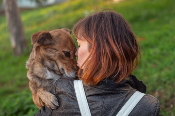 Young woman walking her mongrel dog. Lifestyle with dog. Attractive young woman in casual clothes...