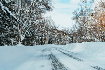 Obraz premium Beautiful snow road forest view during car driving in winter season. Winter travel, Road trip, Adventure, Exploring and Vacation concepts