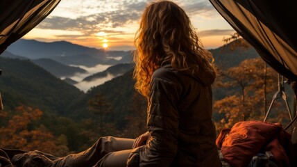 Lonely woman with tent, relaxing in quiet mountain landscape at sunset