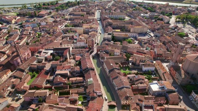 Comacchio, Italy, drone tilt-down view of urban infrastructure, city's canal, little Italian city, sunny weather