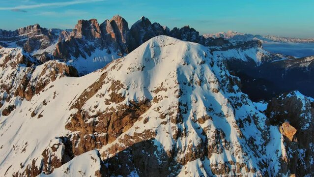 Aerial around view of amazing rocky mountains in snow at sunrise, Dolomites, Italy, 4k