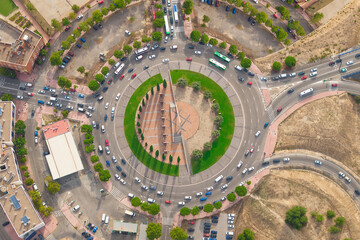 Aerial view of car traffic at circle roundabout intersection with fast moving heavy traffic. Urban...