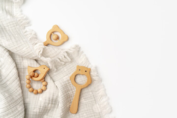 Muslin swaddle blanket with wooden toys on white background