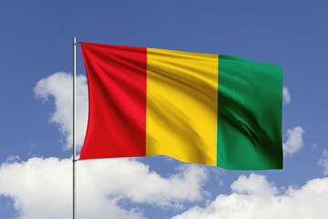 Guinea flag fluttering in the wind on sky.