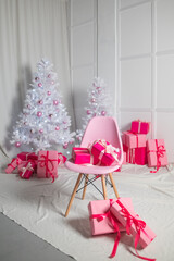 Gift boxes in pink lie under the Christmas tree on New Year's Eve